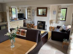 a living room with couches and a wooden table at Woodside Cottage Grewelthorpe Nr Masham in Grewelthorpe
