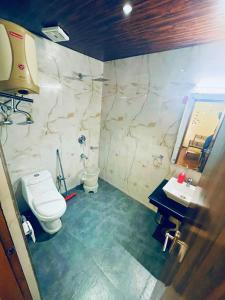 een badkamer met een toilet, een wastafel en een spiegel bij Amrit Villa by Navneet Tourist in Manāli