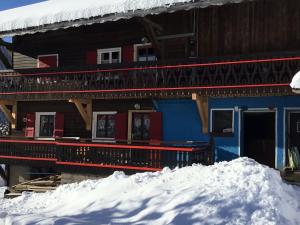 une maison bleue et rouge avec de la neige devant elle dans l'établissement Appartement 3 pièces à Châtel, 6 pers, proche télécabine, balcon exposé sud/ouest - FR-1-676-49, à Châtel