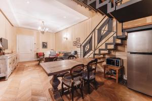 a kitchen and dining room with a table and a staircase at La Croce d'Oro Santa Croce Suite Apartments in Florence