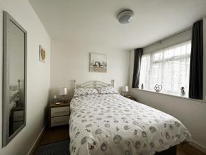 ein weißes Schlafzimmer mit einem Bett und einem Fenster in der Unterkunft Hidden Corner in Sandown
