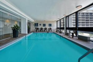 a swimming pool with blue water in a building at Four Points by Sheraton Boston Newton in Newton