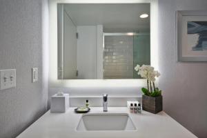 un bagno bianco con lavandino e specchio di Four Points by Sheraton Boston Newton a Newton
