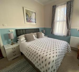 Un dormitorio con una cama grande y una ventana en Buckingham Lodge Guest House, en Torquay