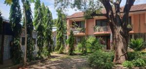 dom z drzewem przed nim w obiekcie PRIMESHADE GUESTHOUSE w mieście Malindi