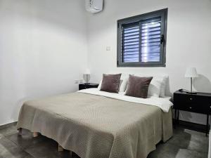 a white bedroom with a large bed with a window at New 2 Bed Rooms with 2 Balconies in Tel Aviv