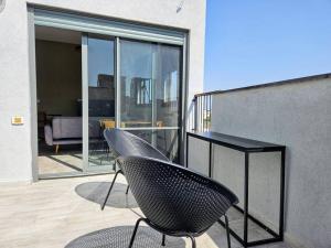 a pair of chairs and a table on a balcony at New 2 Bed Rooms with 2 Balconies in Tel Aviv