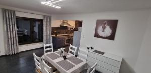 uma sala de jantar com mesa e cadeiras e uma cozinha em Ferienhaus Schmidt em Schmalkalden