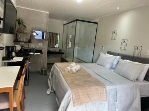 um quarto de hotel com uma cama com toalhas em Chalé 01 com hidro e cozinha no coração de Penedo em Itatiaia