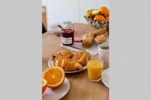 stół z talerzami wypieków i sokiem pomarańczowym w obiekcie Appartement6P/New&FullEquipped/NATION/FG StANTOINE w Paryżu
