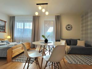 a living room with a couch and a table and chairs at Apartamenty Velvet in Kościelisko