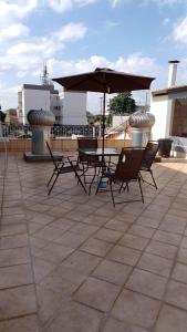a table and chairs with an umbrella on a roof at POUSADA DAS NAÇÕES ll in Indaiatuba +12 photos