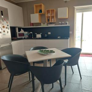 a kitchen with a table and chairs and a refrigerator at Dimora Kalypso in Polignano a Mare