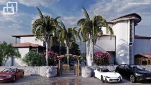 dos coches aparcados frente a una casa con palmeras en Marvelous Hotel, en Sarigerme
