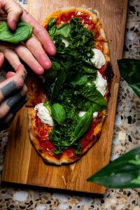 a person is preparing a pizza on a cutting board at Hobo Helsinki in Helsinki