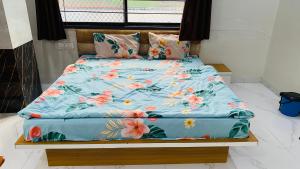 uma cama com um edredão azul com flores em Hotel Anmol Resort em Indore