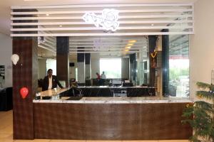 um homem parado atrás de um balcão num restaurante em Hotel Anmol Resort em Indore