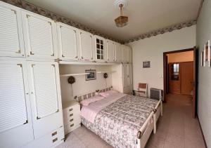 - une chambre avec un lit et quelques placards blancs dans l'établissement Diano Marina - Garofani, à Diano Marina