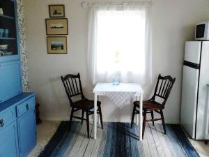 La cuisine est équipée d'une table, de deux chaises et d'un réfrigérateur. dans l'établissement Cozy cottage in Aleklinta, north of Borgholm, close to the sea, à Borgholm
