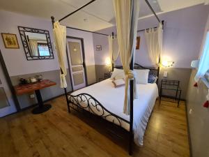 a bedroom with a canopy bed and a mirror at Gîte et Chambres d'hôtes, l'Erable in Beblenheim