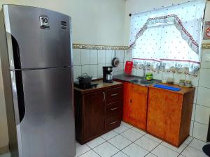 プンタレナスにあるCasa equipada en el centro de Puntarenasのキッチン(ステンレス製の冷蔵庫、木製キャビネット付)