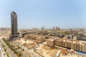 an aerial view of a city with a tall building at Experience Serenity at Binghatti Crest in JVC in Dubai