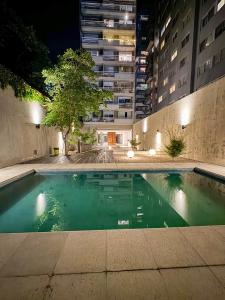 una piscina en medio de un edificio por la noche en Foster Palermo Hollywood en Buenos Aires