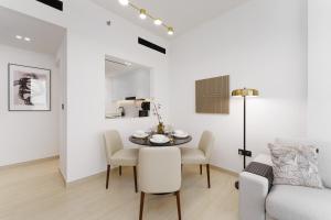 a white living room with a table and a couch at Experience Serenity at Binghatti Crest in JVC in Dubai