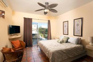 una camera da letto con un letto e un ventilatore a soffitto di Tooker Villa La Jolla San José del Cabo a San José del Cabo