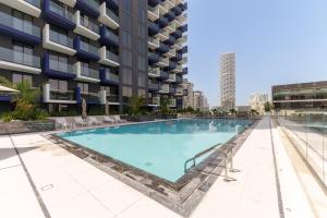 a swimming pool in front of a building at Experience Serenity at Binghatti Crest in JVC in Dubai