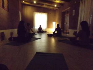 un grupo de personas sentadas en una habitación haciendo yoga en Hotel Poblado Kimal en San Pedro de Atacama