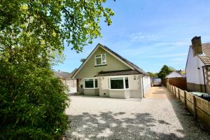 a house with a garage and a driveway at Four Corners Holiday Home Hot Tub & Sauna in Ferndown