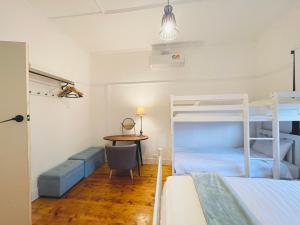 a bedroom with two bunk beds and a table at D114 Victorian Central Stay in Melbourne