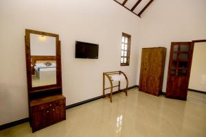 a room with a mirror and a bed in it at Ari Guest House in Anuradhapura