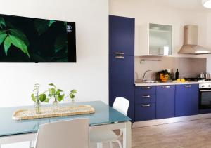 une cuisine avec des placards bleus et une table bleue dans l'établissement HoliHome_Casa di Sara, à Tortoreto Lido