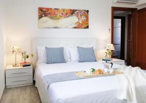 una camera da letto con un letto bianco e un vassoio di cibo sopra di HoliHome_Casa di Sara a Tortoreto Altre 18 foto