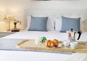 - un plateau de croissants et des tasses à café sur le lit dans l'établissement HoliHome_Casa di Sara, à Tortoreto Lido