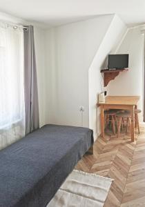 a small bedroom with a bed and a desk at Czarny Jeleń in Zakopane