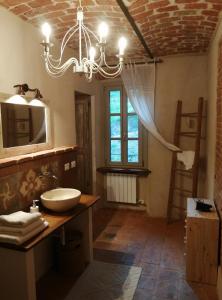 a bathroom with a sink and a chandelier at La casa in collina in Cinzano