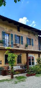 un grande edificio in mattoni con finestre con persiane blu di La casa in collina a Cinzano