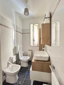 Baño blanco con aseo y lavamanos en L'host in Taormina en Taormina