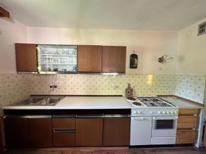 a kitchen with a white stove and a sink at Apartma Žagar Robert in Log pod Mangartom
