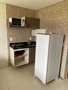 uma cozinha com um frigorífico branco e um micro-ondas em Flat mobiliado,o mais aconchegante de campina grande em Campina Grande