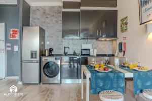 a kitchen with stainless steel appliances and a table at Ocean Paradise - Apartment with ocean view in Ericeira