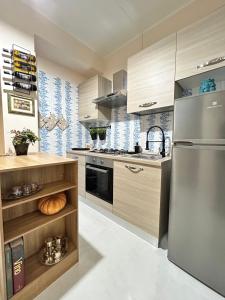 a kitchen with a stainless steel refrigerator and wooden cabinets at L'host in Taormina in Taormina