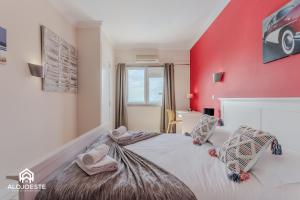 a bedroom with a red wall and a bed at Ocean Paradise - Apartment with ocean view in Ericeira