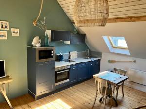 a kitchen with blue cabinets and a table in a room at 1Somme En Baie in Cayeux-sur-Mer