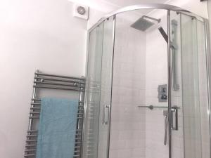 a bathroom with a shower with a glass door at House with garden in Hertford in Hertford