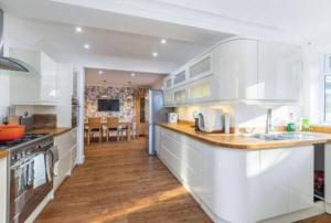 a kitchen with white cabinets and a counter top at House with garden in Hertford in Hertford