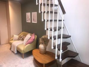 a living room with a couch and a spiral staircase at House with garden in Hertford in Hertford